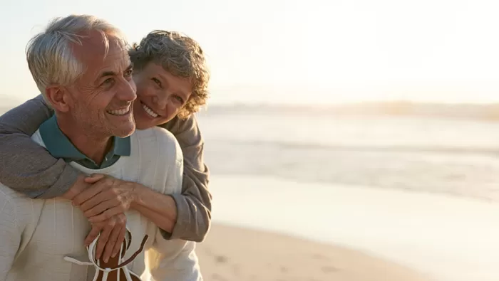 happy retired couple on beach