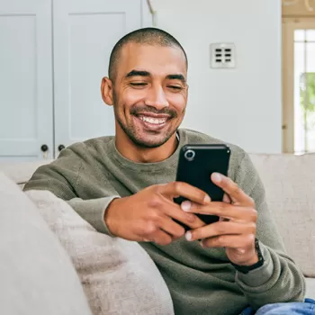 man using phone on couch